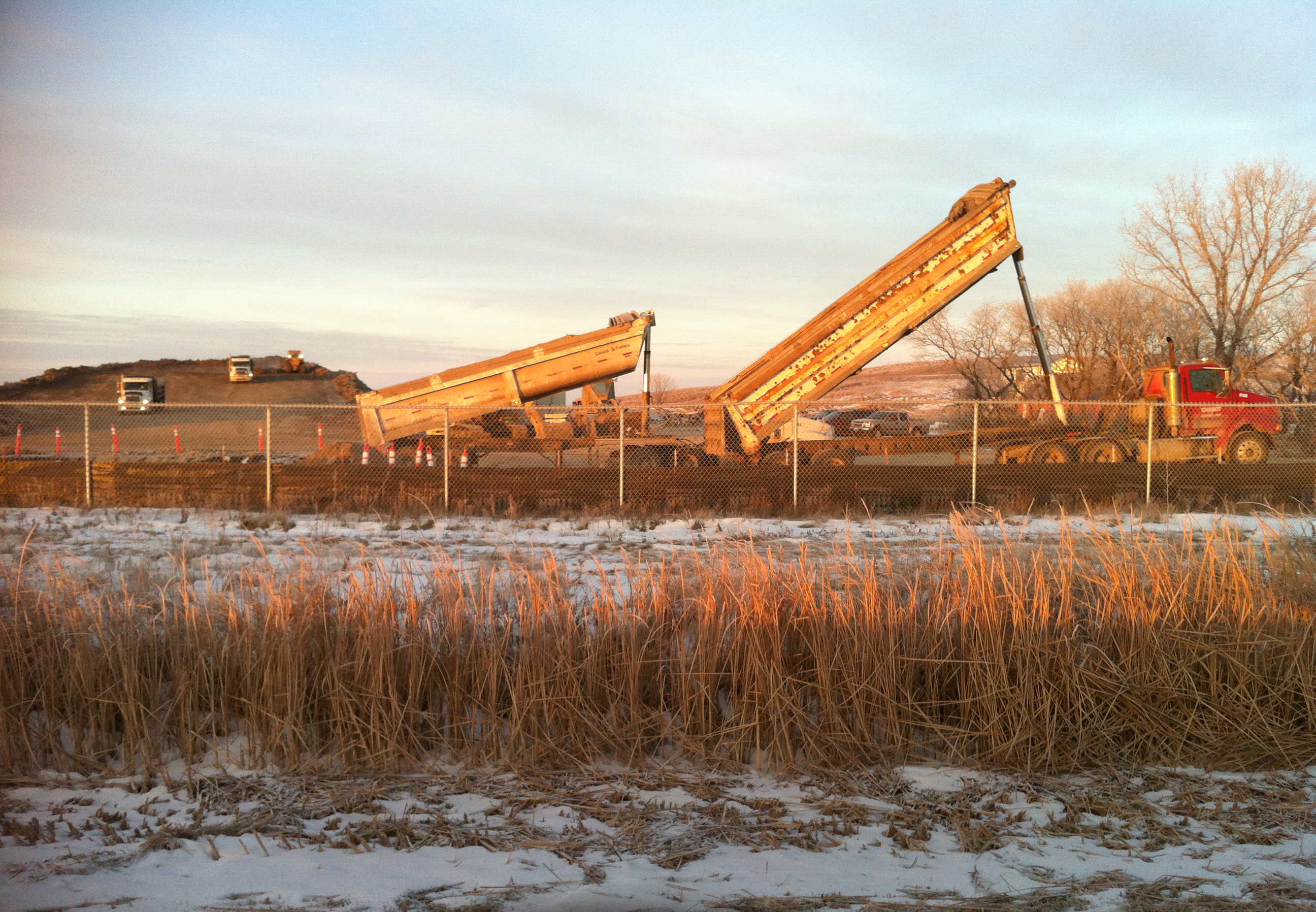 Crews tipping lime mud material at the berm site
